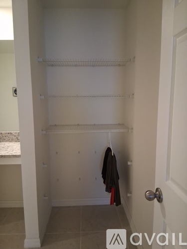 A hallway with a coat hanging on the rack.