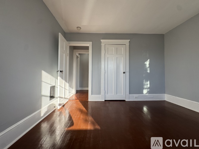 A long hallway with a white door at the end.