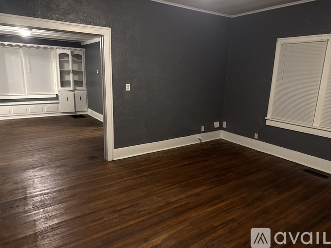A room with wooden floors and a wall-mounted mirror.