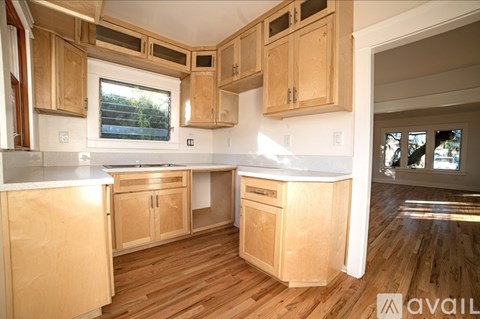 A kitchen with wooden cabinets and a window.