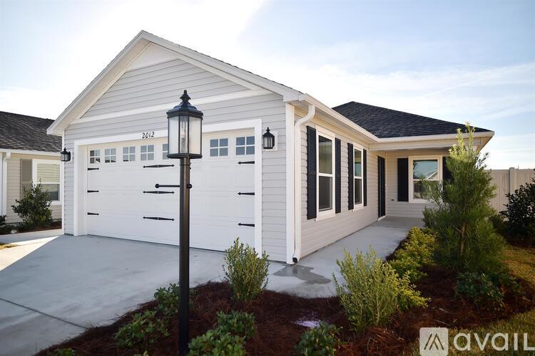 A house with a white exterior and a black lamp post in front.
