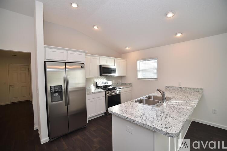 A kitchen with granite countertops and stainless steel appliances.