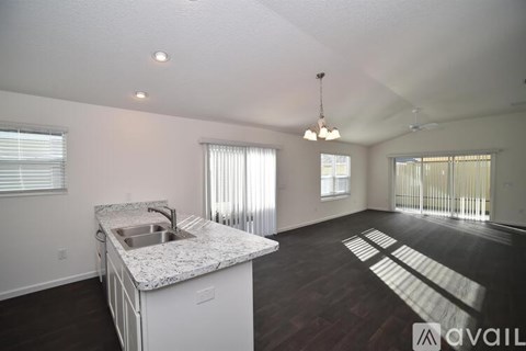 A kitchen with a granite countertop and a sink is available for rent.
