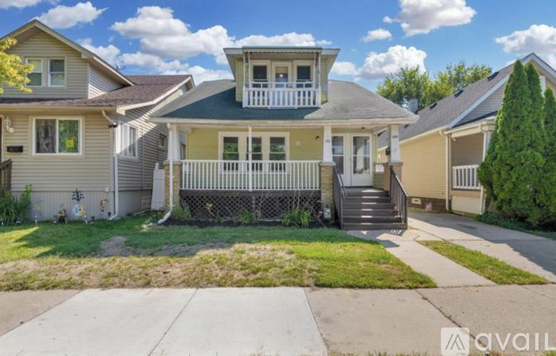 A house with a green roof and a porch with a railing.