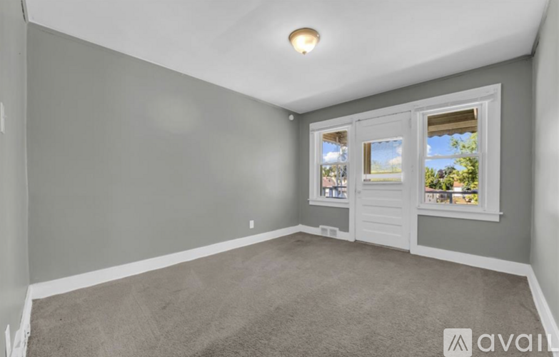 A room with a carpeted floor and a window showing a view of the outside.