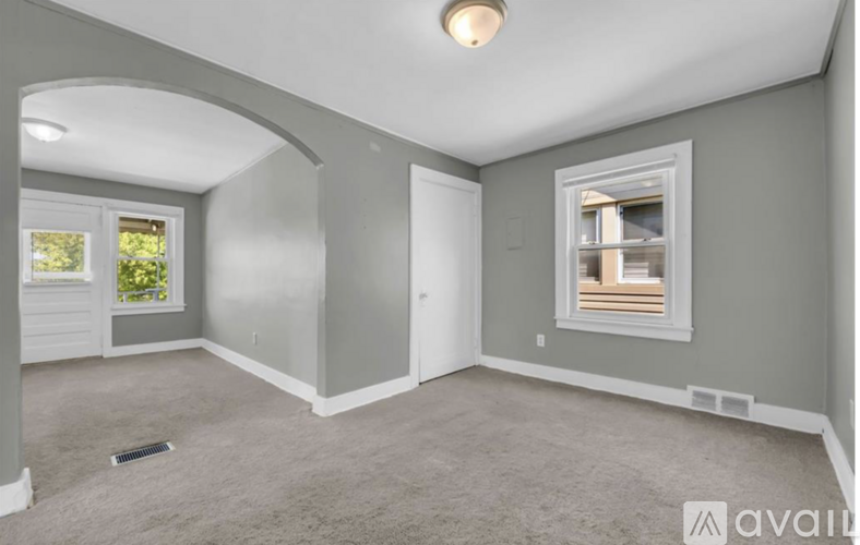 A spacious room with a window and a door.