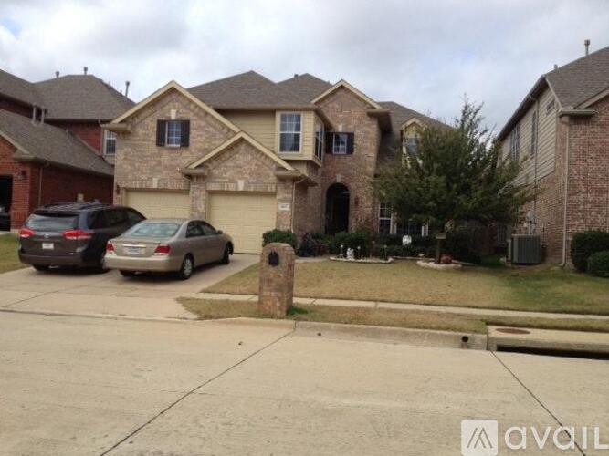 A house with a driveway and two cars parked in front.