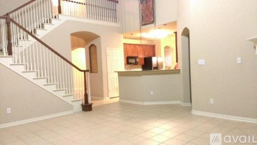 A spacious living room with a staircase leading to the upper floor.