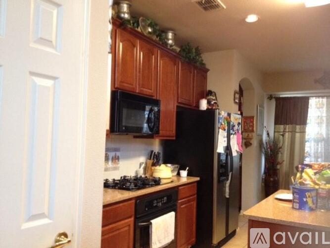 A kitchen with wooden cabinets and a black refrigerator.