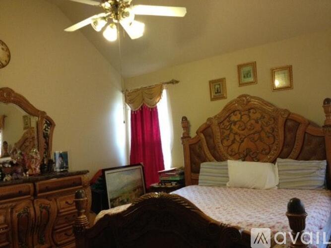 A bedroom with a large bed and a ceiling fan.