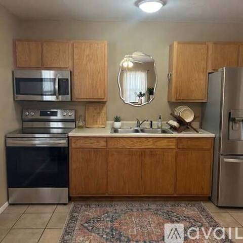 A kitchen with wooden cabinets and a stainless steel oven.