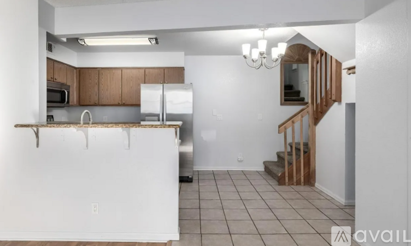 A kitchen with white appliances and brown cabinets.