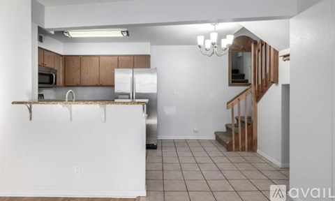 A kitchen with white appliances and brown cabinets.