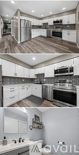 A modern kitchen with white cabinets and stainless steel appliances.