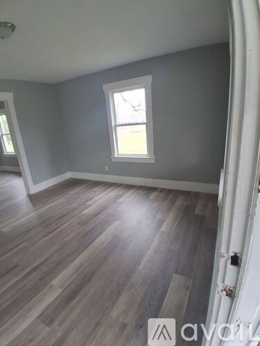 A room with wooden flooring and a window.
