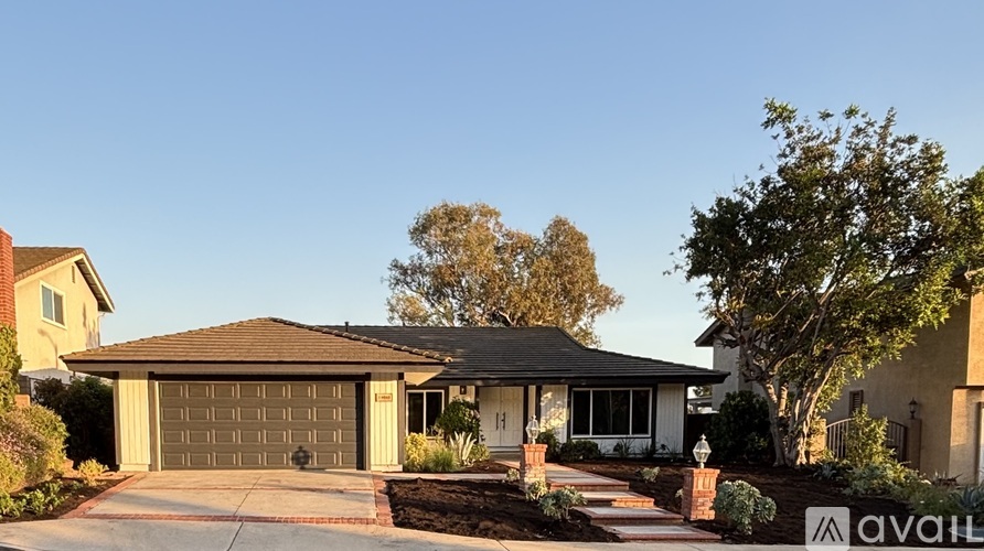 A house with a garage and a driveway in front of it.