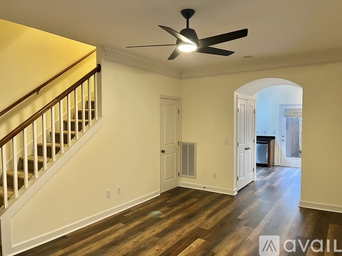 A room with a staircase and a ceiling fan.