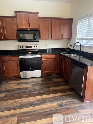 A kitchen with wooden cabinets and a black countertop.