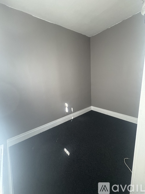 A room with a black floor and grey walls.