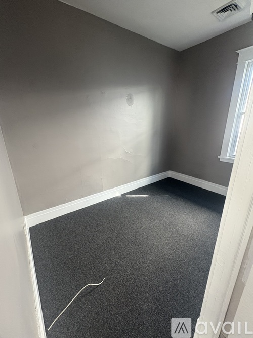 A room with grey carpet and white walls.