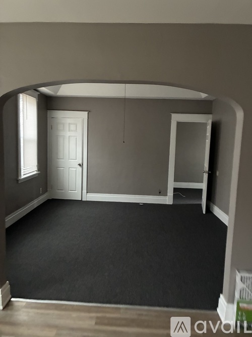A room with a white door and a grey wall.