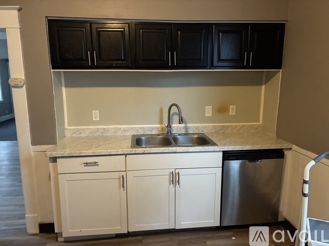A kitchen with black cabinets and white countertops.