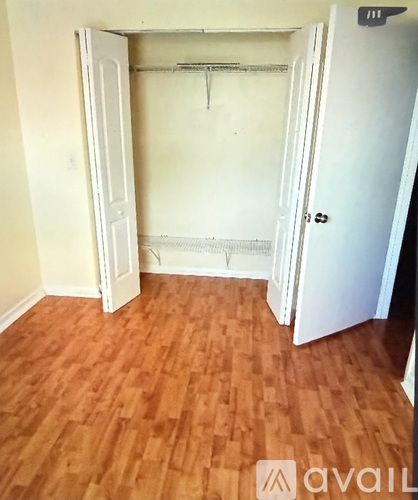 A room with a wooden floor and a white door.