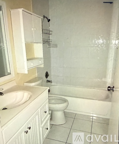 A white bathroom with a toilet, sink, and bathtub.