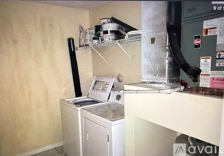 A white cabinet with a black handle is on the floor.