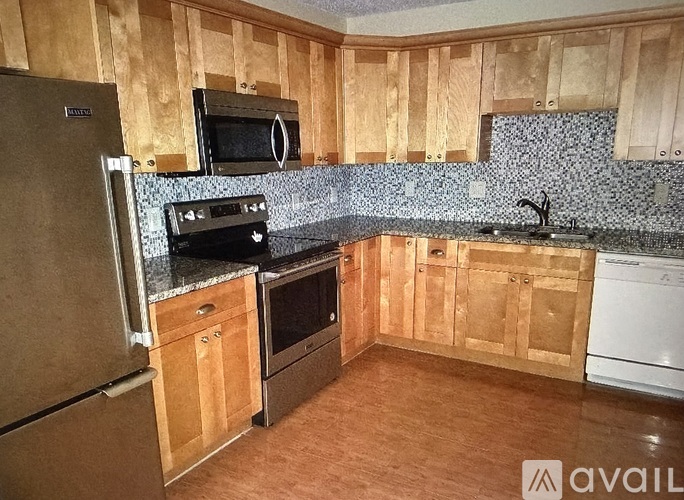 A kitchen with wooden cabinets and a black oven.