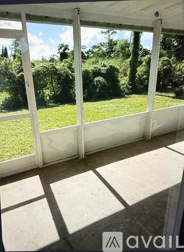 A white tent with a view of a green lawn and trees.