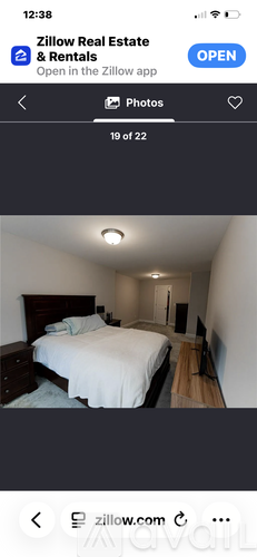 A bedroom with a bed, dresser, and mirror.