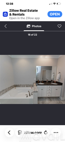 A bathroom with a bathtub and a vanity with a mirror.