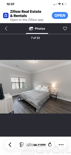 A bedroom with a large bed and a window.