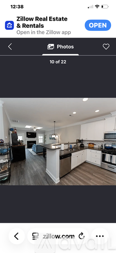 A kitchen with white cabinets and a black countertop.