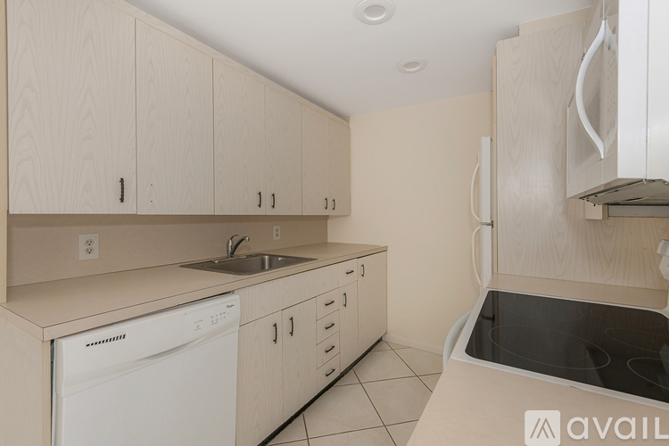 A kitchen with white appliances and cabinets.