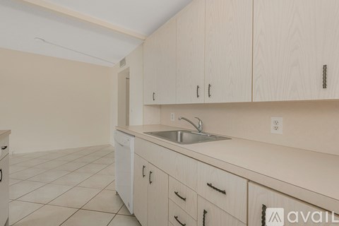 A kitchen with wooden cabinets and a white sink.