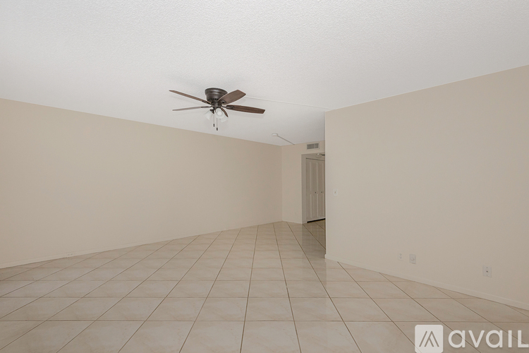 A room with a ceiling fan and tiled flooring.