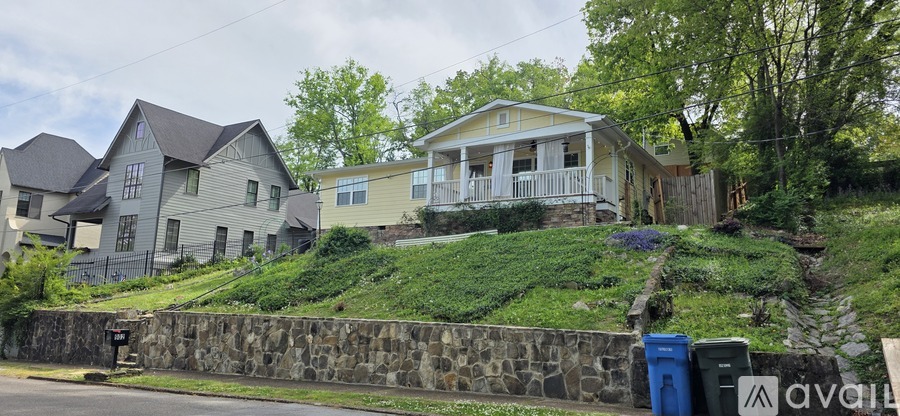 A house with a stone wall in front of it.