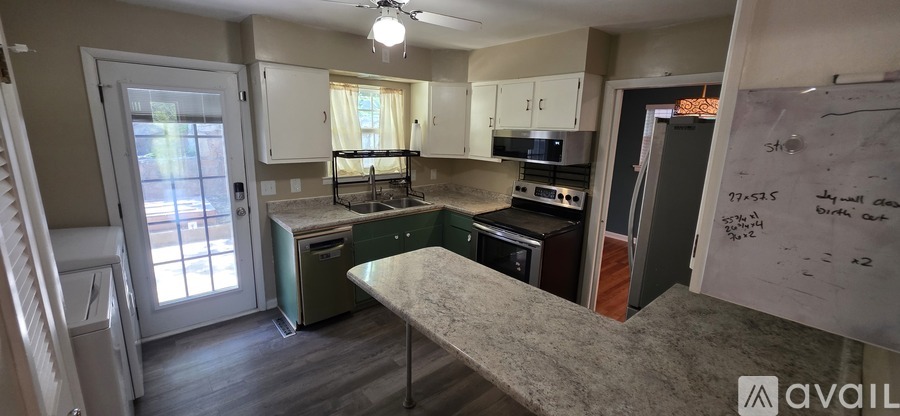 A kitchen with a whiteboard on the wall.