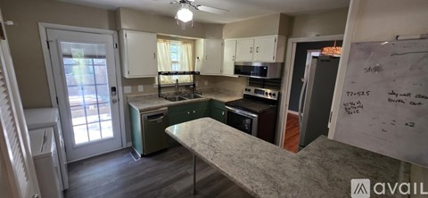 A kitchen with a whiteboard on the wall.