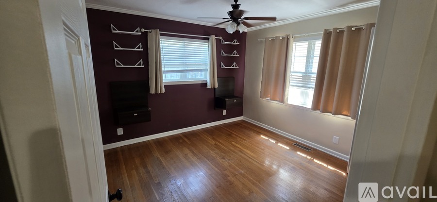 A room with a ceiling fan and a wall-mounted TV.