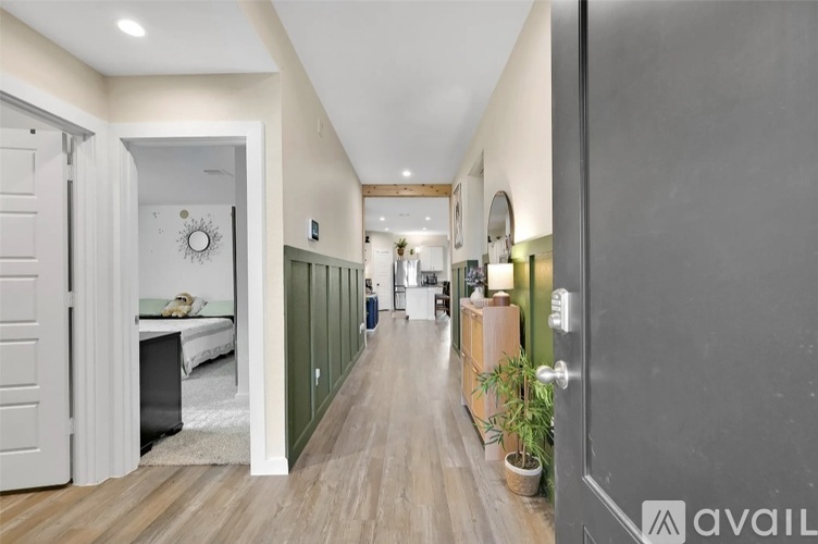 A hallway with a white door on the left and a dark door on the right.