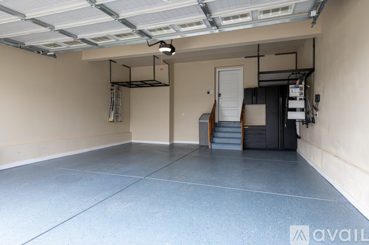 A spacious garage with a concrete floor and a ceiling with exposed ductwork.