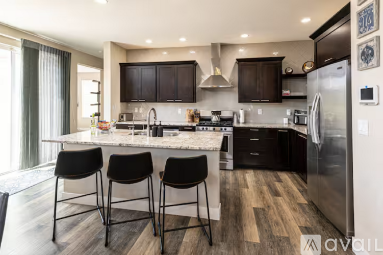 A modern kitchen with a marble countertop and stainless steel appliances.