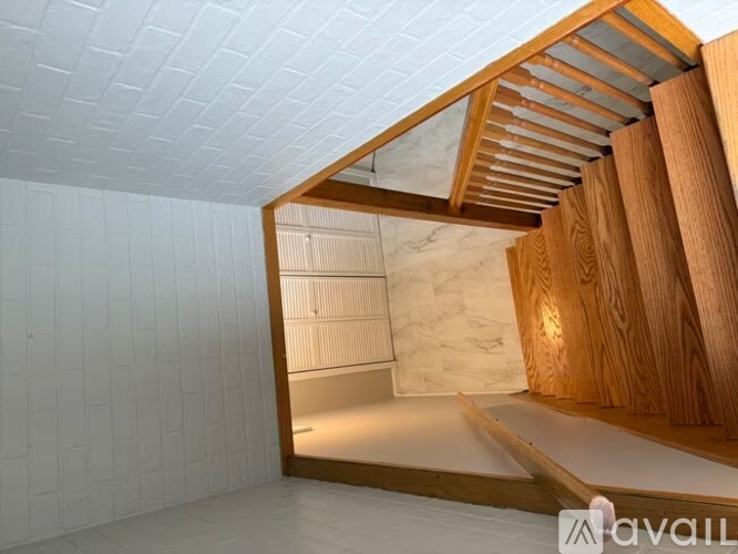 A room with a white tiled wall and a wooden beam ceiling.