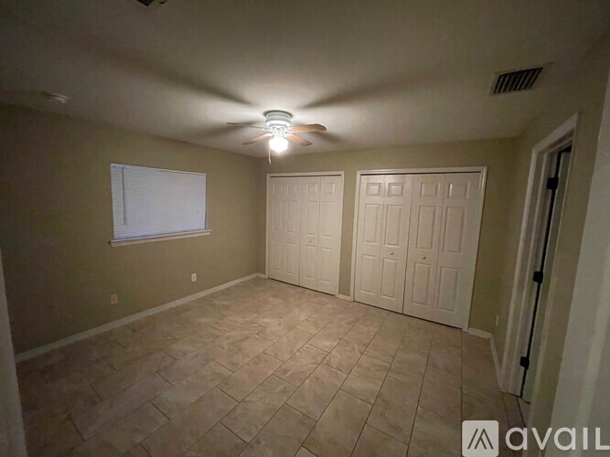 A room with a ceiling fan and tiled floor.