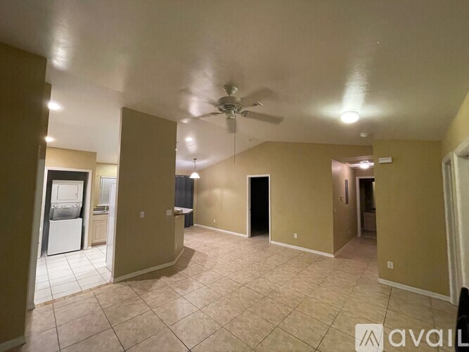 A spacious room with a ceiling fan and tiled flooring.