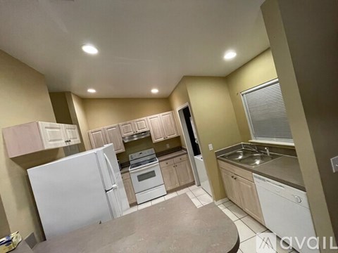 A kitchen with white appliances and wooden cabinets.