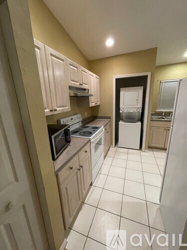 A kitchen with white appliances and cabinets.